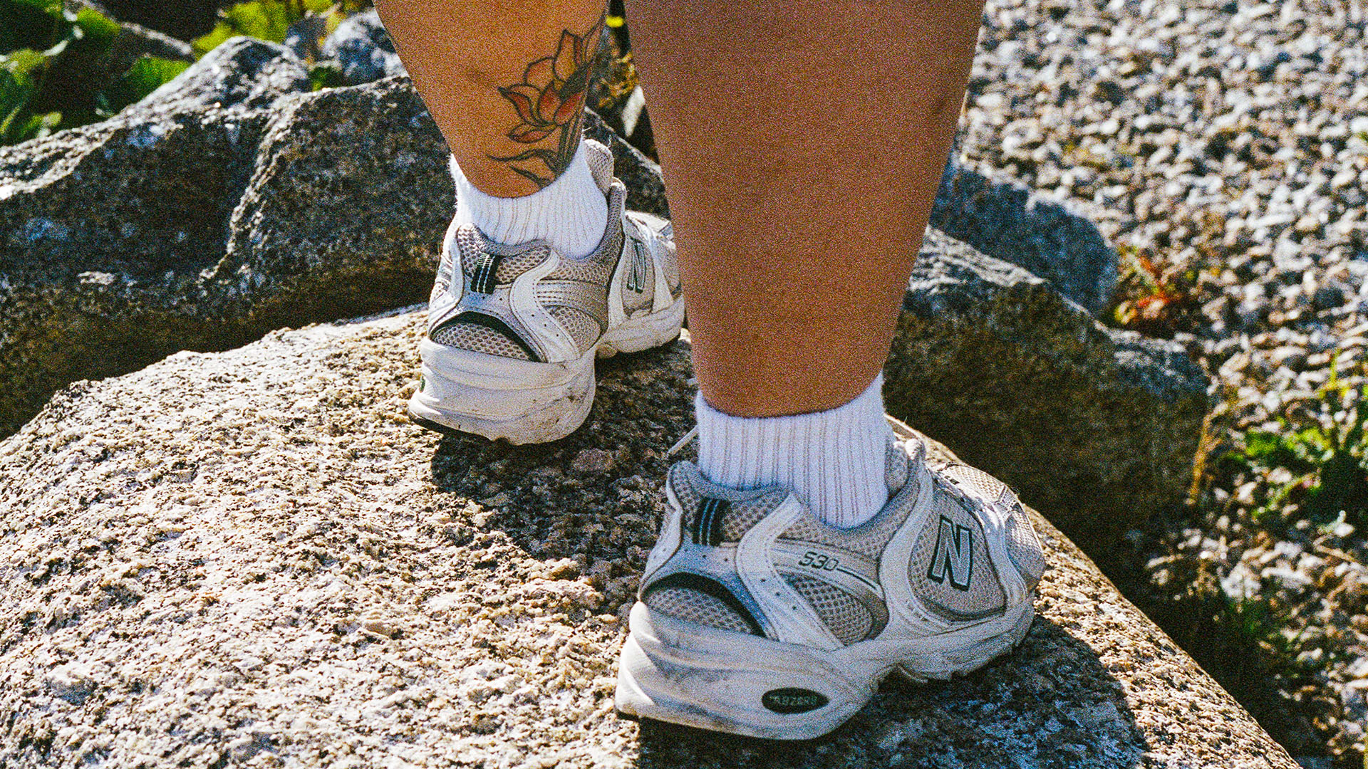 Persons calves standing on rocks.